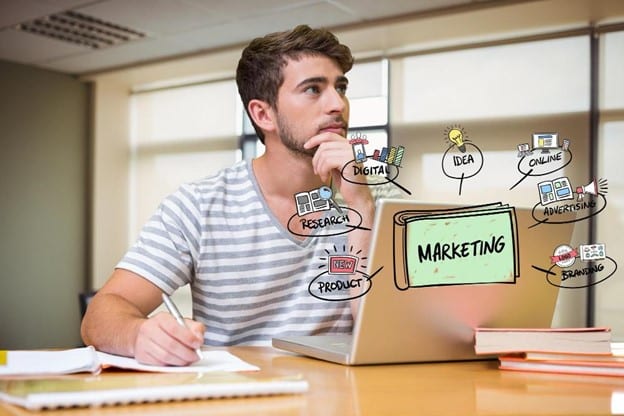 thoughtful marketer at a desk with content marketing strategy doodles around him, indicating concepts like research, ideas..